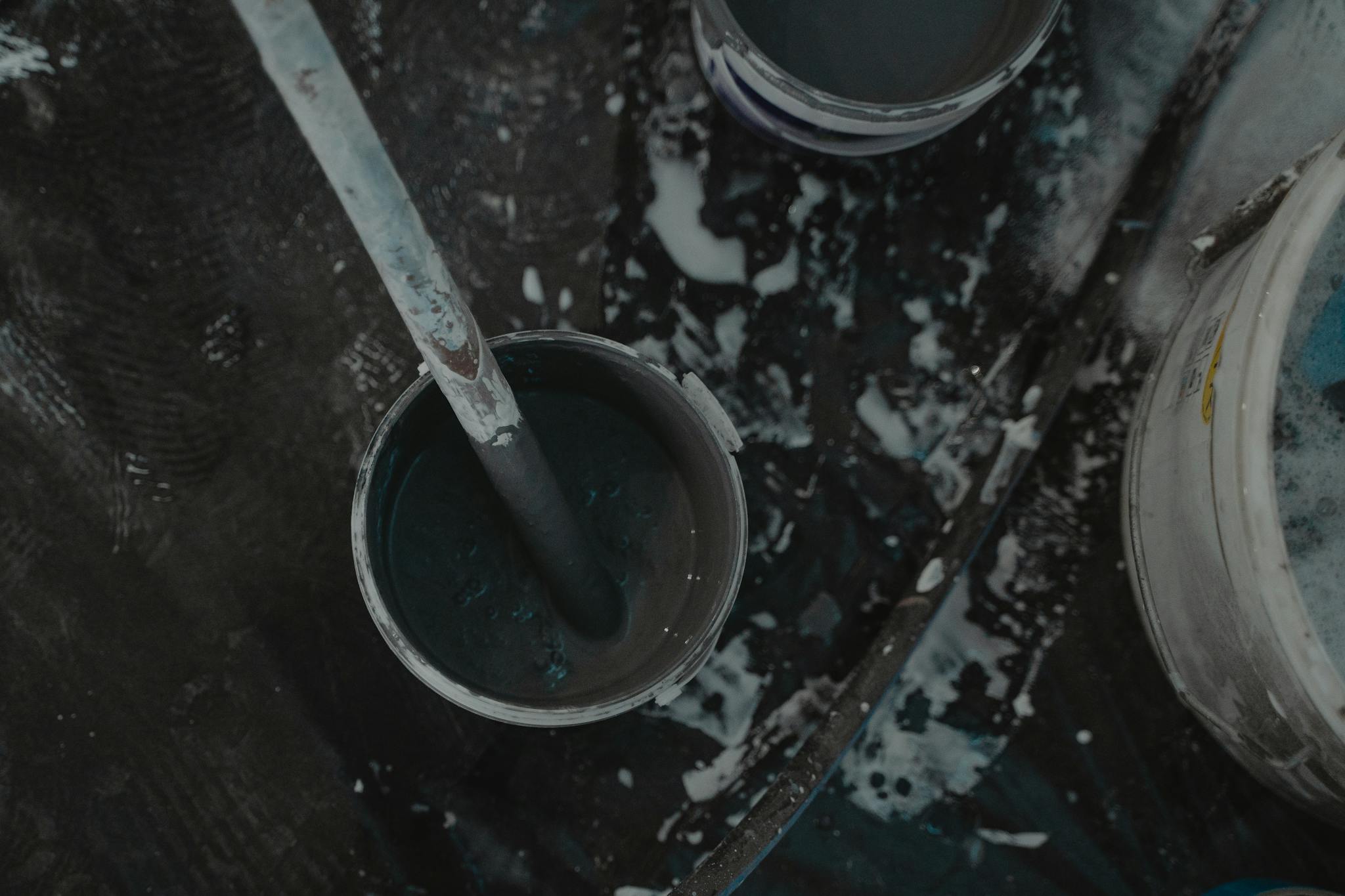 Aerial shot of paint buckets and tools on a construction site, showcasing a renovation project.